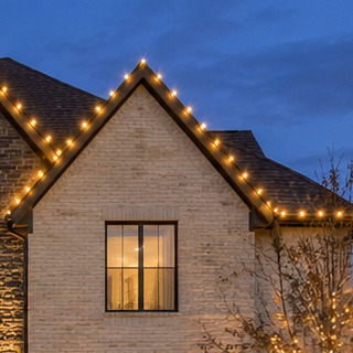 Close view of warm C9 bulbs tracing a gable