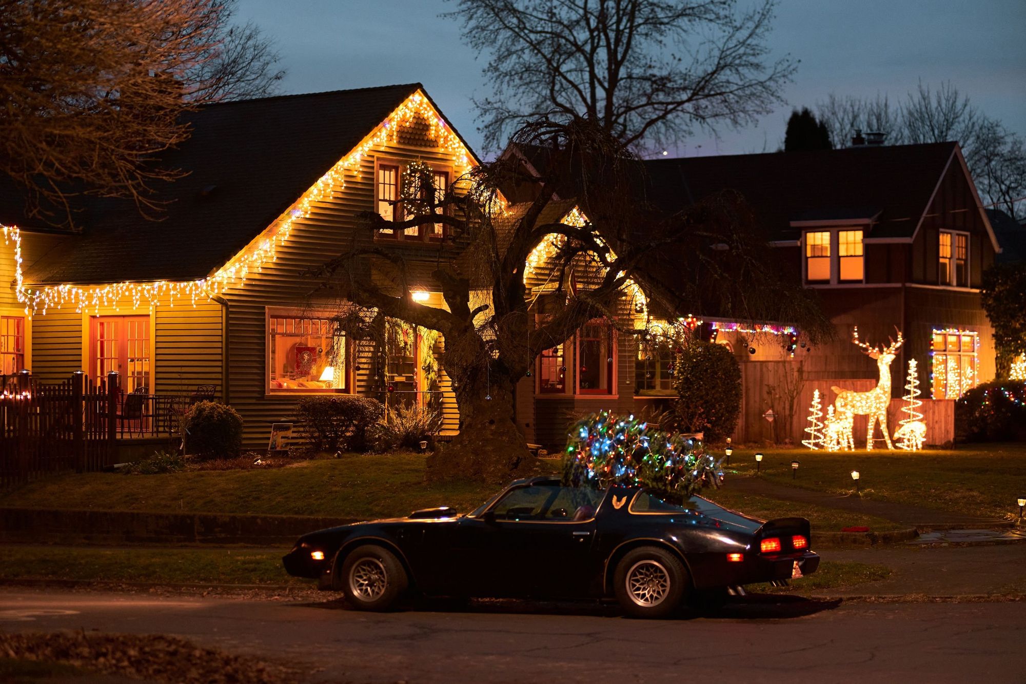 Home at night with warm white lights along the eaves and gables